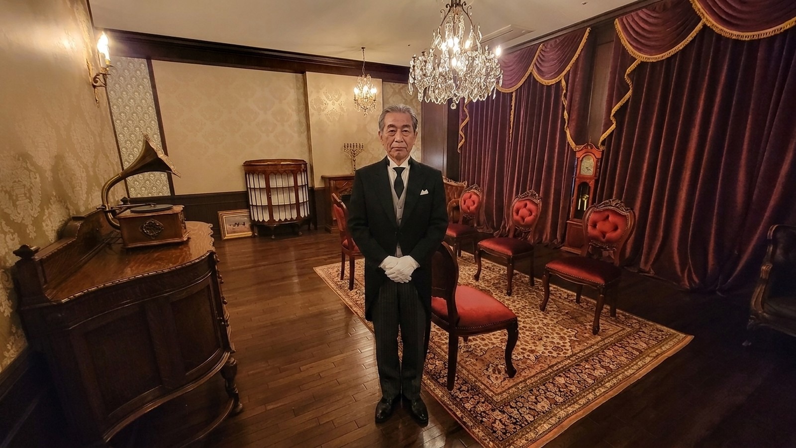 協会のサロンで椅子に着く年長の執事