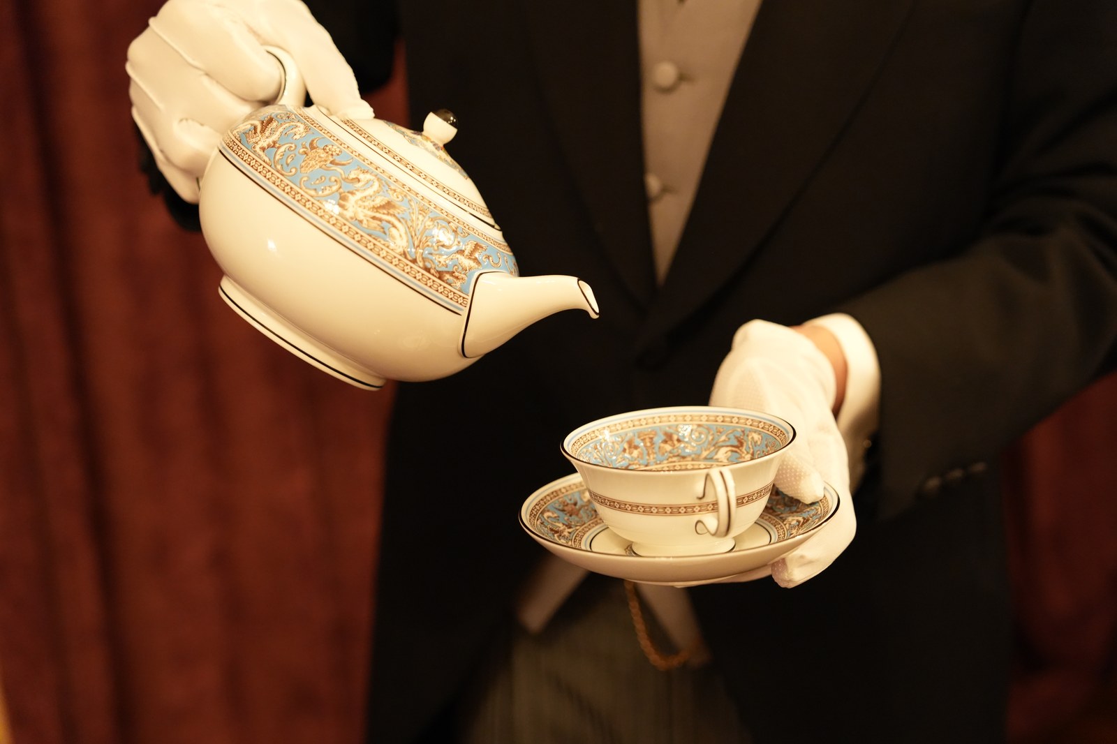 白手袋で茶器から碗へ注ぐ手元